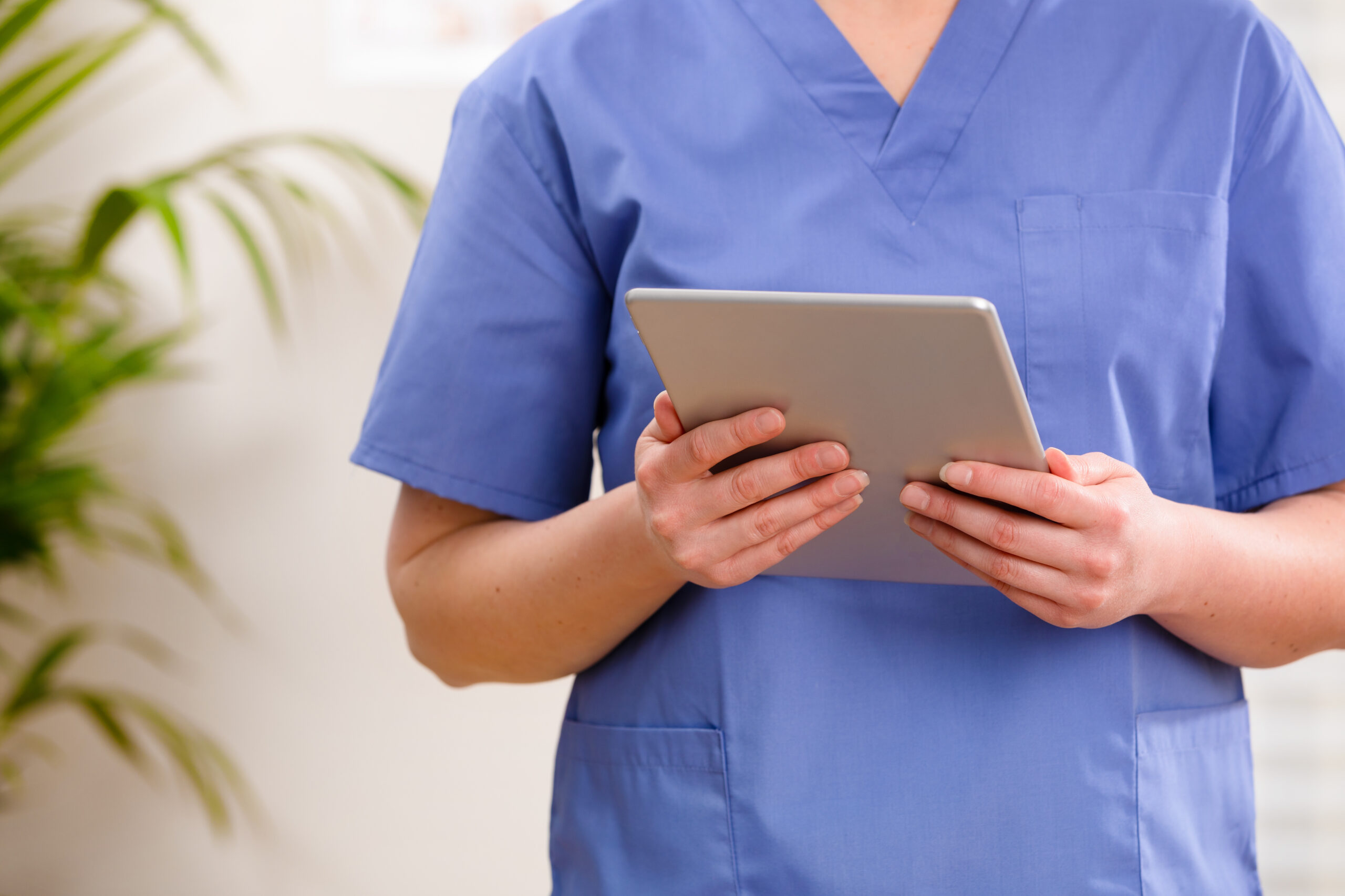 Female doctor or nurse looking at a digital image or report on a tablet in doctors office, climic or hospital. Technology in healthcare services.